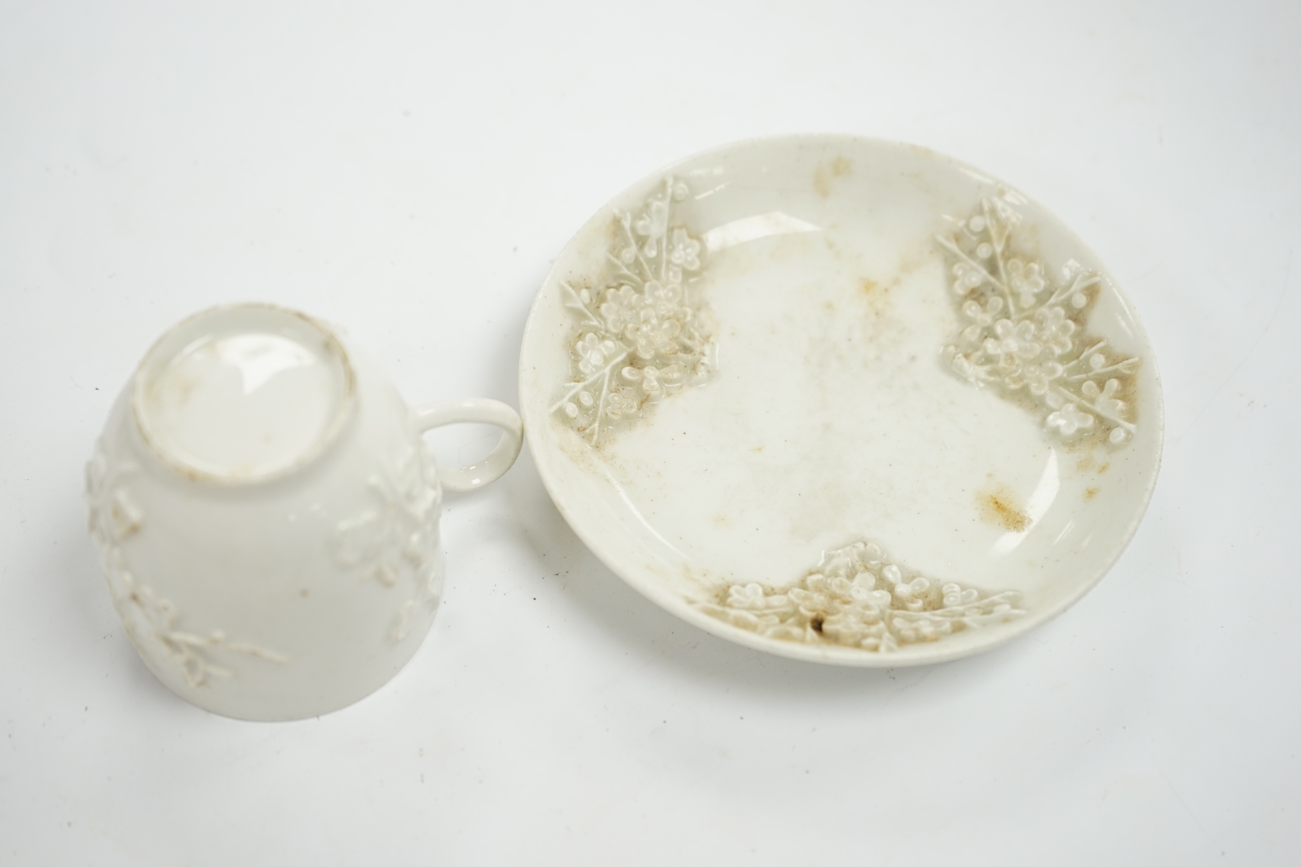 A Bow prunus sprigged coffee cup and saucer, c.1760, saucer 11.5cm diameter, cup 6cm high. Condition - cup has a chip to the rim and both saucer and cup interior have wear to glazing